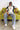 A model sitting on a olive green couch with his hands spread wide wearing Adventures Donald Duck Jersey Zoomed Out Front View from Bonkers Corner